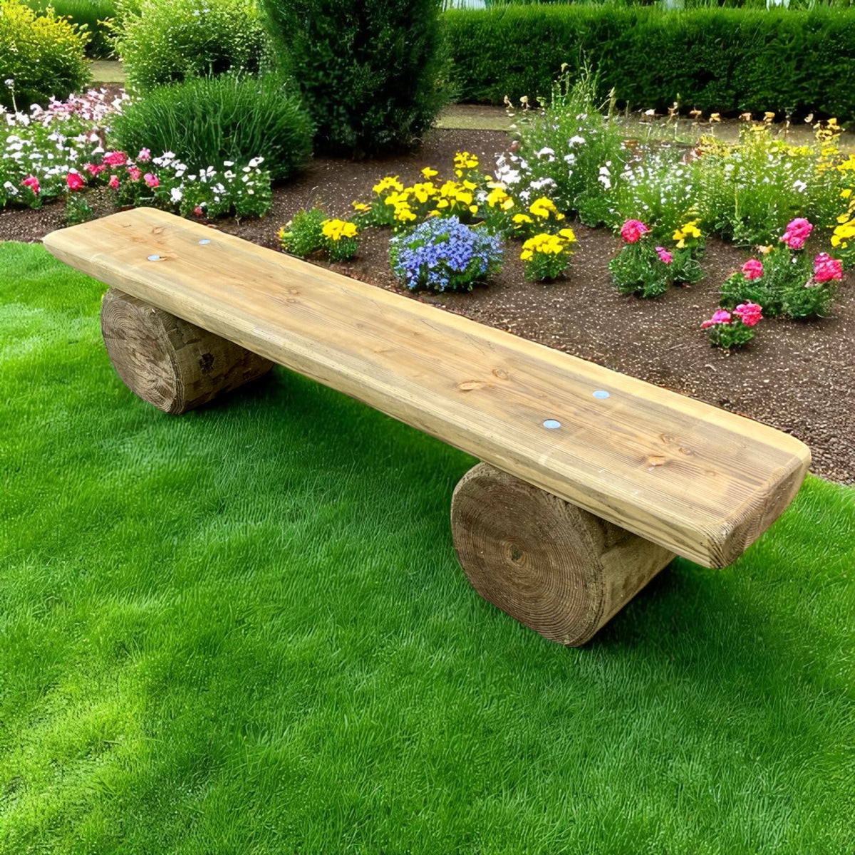 Rustikale Holzbank ohne Lehne im Garten vor einem Blumenbeet auf Rasen