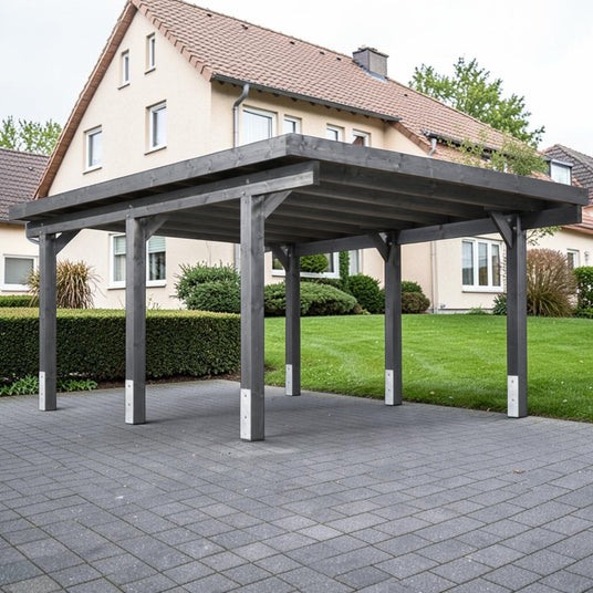 Grau lasierter Holz Carport Eslohe auf gepflasterter Einfahrt vor einem Wohnhaus