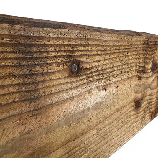 Raue Oberfläche einer braunen Lärchen Bonanzabohle mit Schraube im Detail