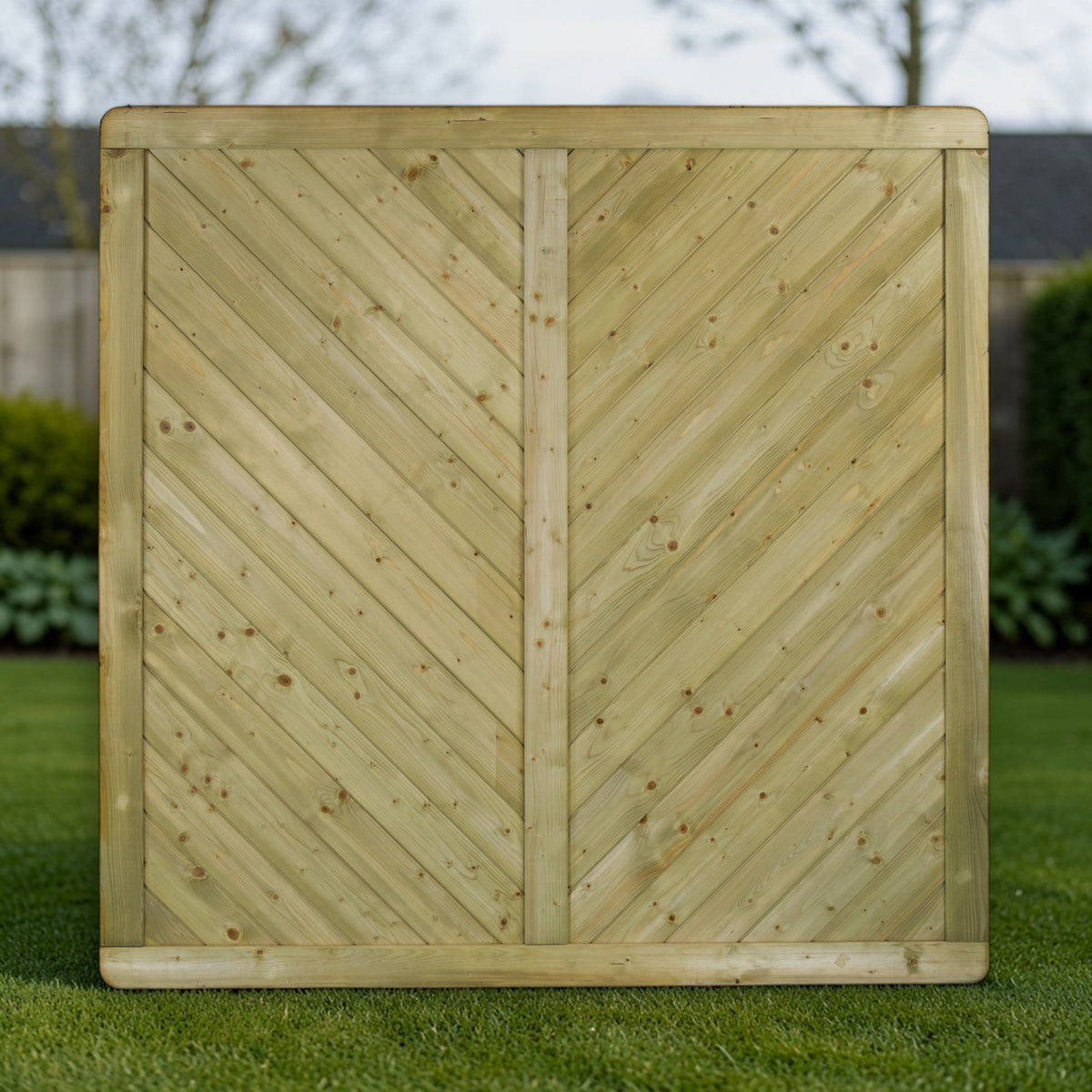 Holz Sichtschutzzaun Hemberg auf Rasen vor einer Hecke als blickdichte Grundstücksgrenze