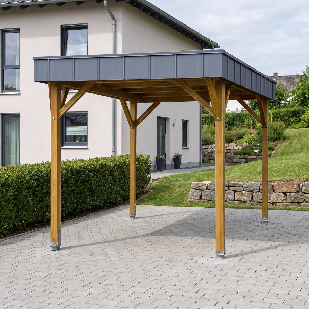 Einzelcarport Arnsberg Premium aus Holz mit anthrazitfarbener Dachblende auf einer gepflasterten Einfahrt