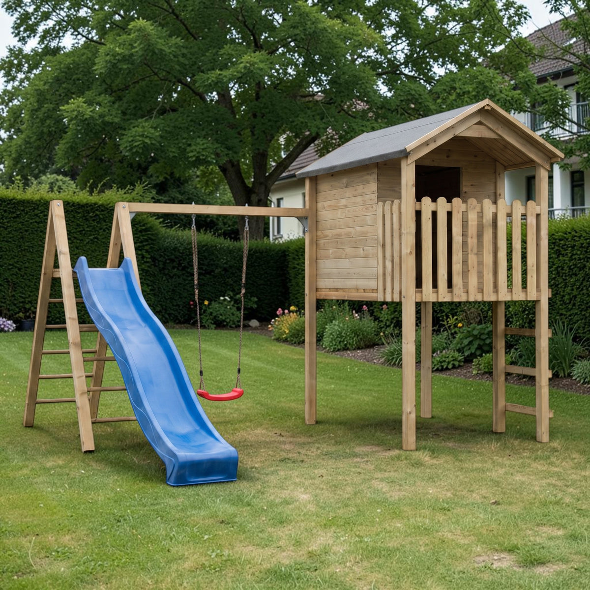 Spielturm Oberkirchen mit Schaukelanbau und blauer Rutsche auf dem Rasen im Garten