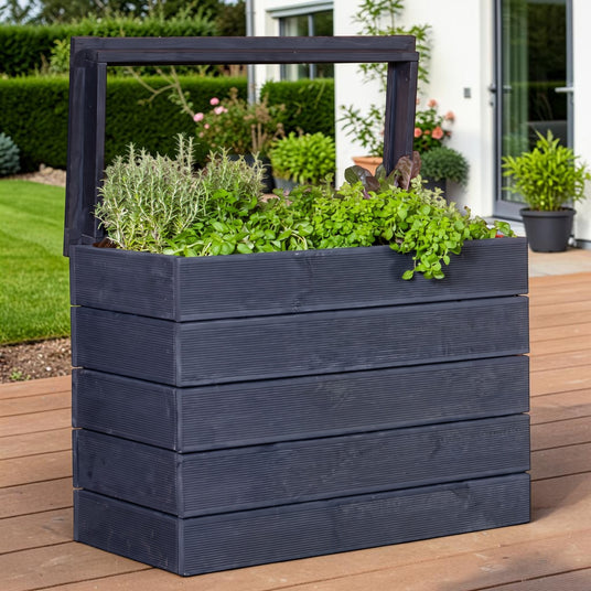 Lasiertes Hochbeet Ahre mit Kräutern auf einer Holzterrasse vor Rasen und Hecke