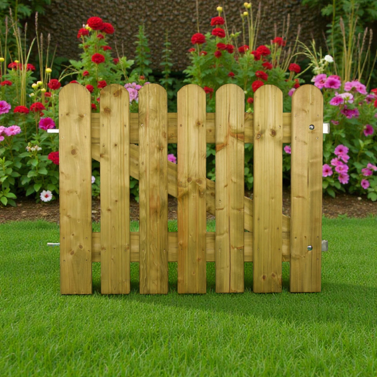 Holz Gartentor mit runden Lattenköpfen auf Rasen vor einem blühenden Blumenbeet