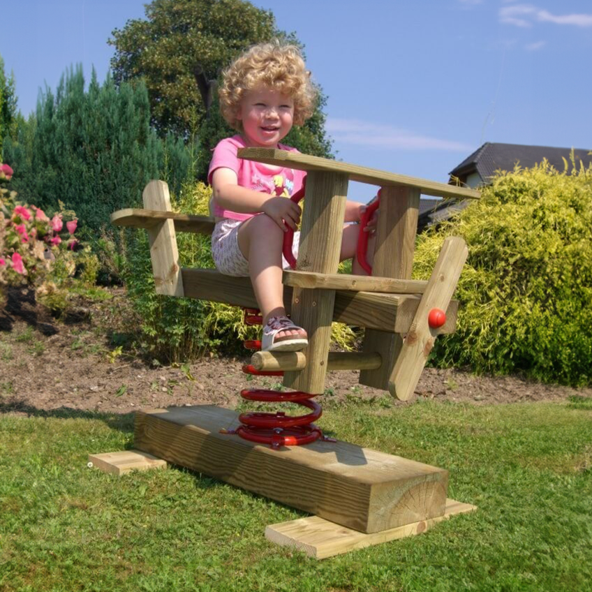 Kind sitzt auf dem Holz Federwipper Flugzeug im Garten