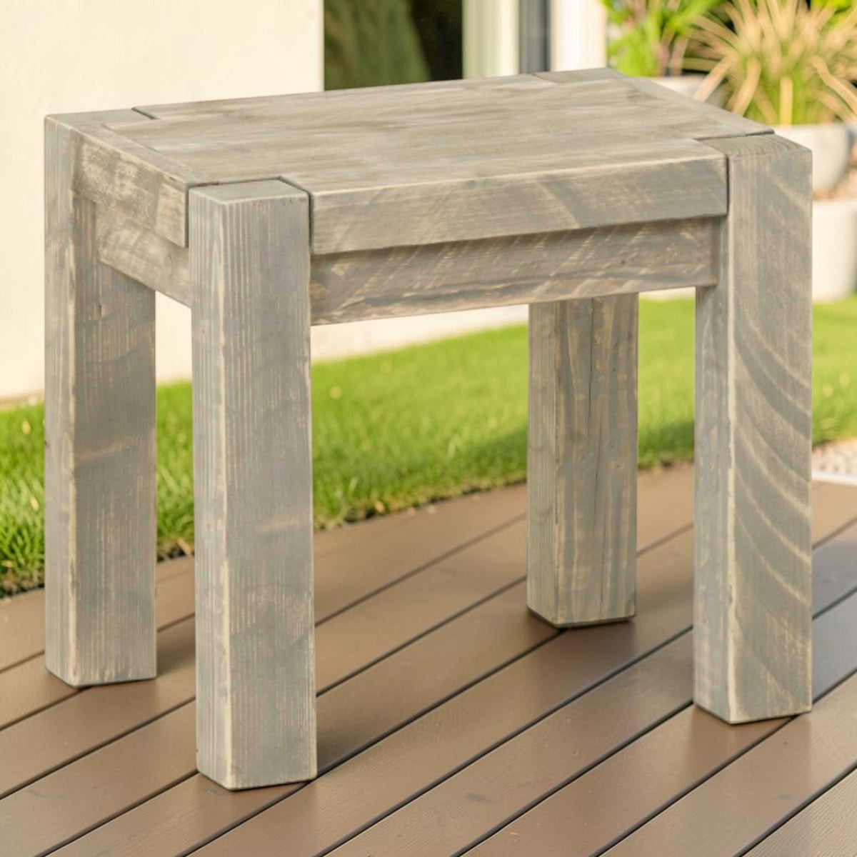 Massivholz Hocker Salweytal auf einer Holzterrasse am Rasen