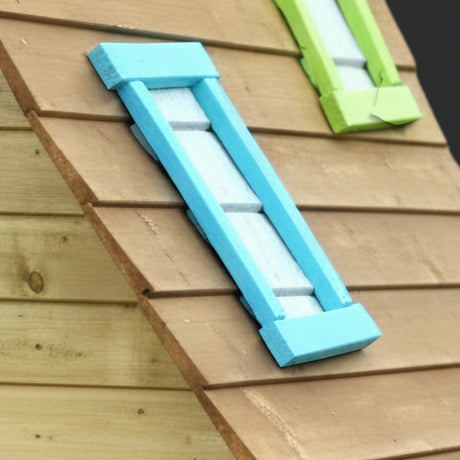 Hellblauer Fensterladen und grünes Dachfenster am Holz Spielhaus in Nahaufnahme