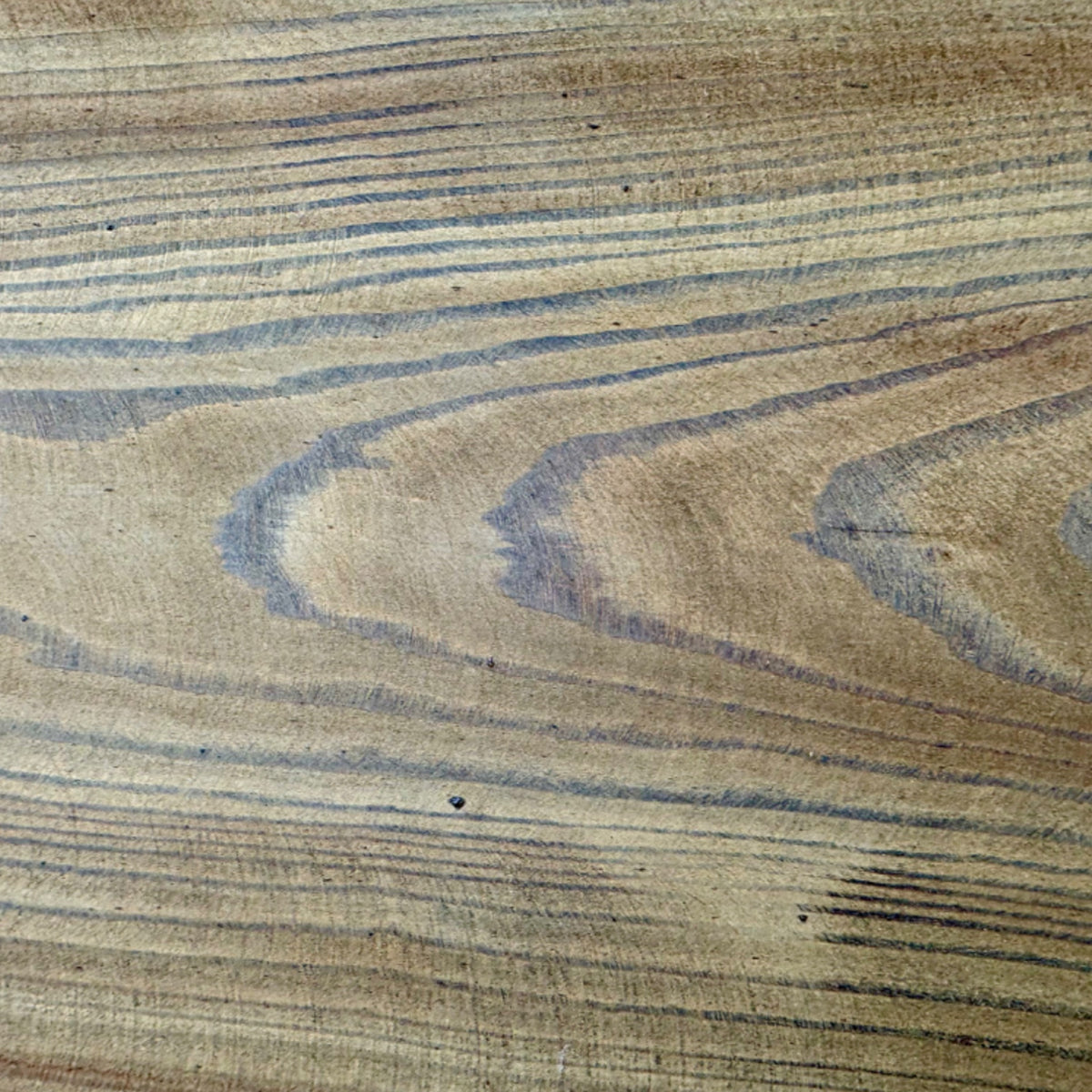 Holzmaserung der Sitzbohle einer rustikalen Gartenbank in Nahaufnahme