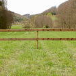 Weidezaun Plankenzaun Komplettset kesseldruckimprägniert mit runden Pfählen und zwei Planken auf einer Weide