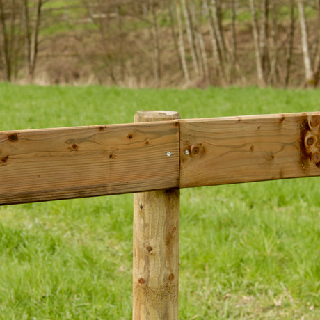 Holzplanke am runden Pfahl des Plankenzauns verschraubt, Nahaufnahme