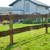 Holz Weidezaun mit Vierkantpfosten als Grundstücksgrenze auf Rasen vor einem Wohnhaus