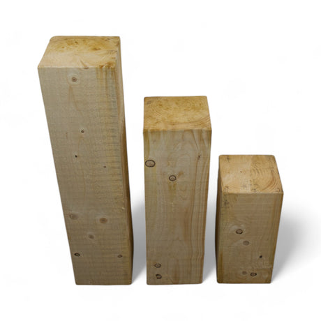 Massive Holzsäulen aus Nadelholz in drei Höhen nebeneinander, Freisteller