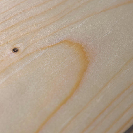Holzoberfläche eines naturbelassenen Rauspundbretts mit Maserung und Ast im Detail