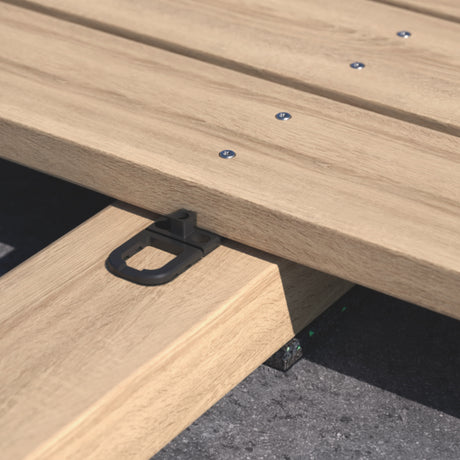 Schwarzer Dielenverbinder unter verlegten Terrassendielen auf der Unterkonstruktion, Detail