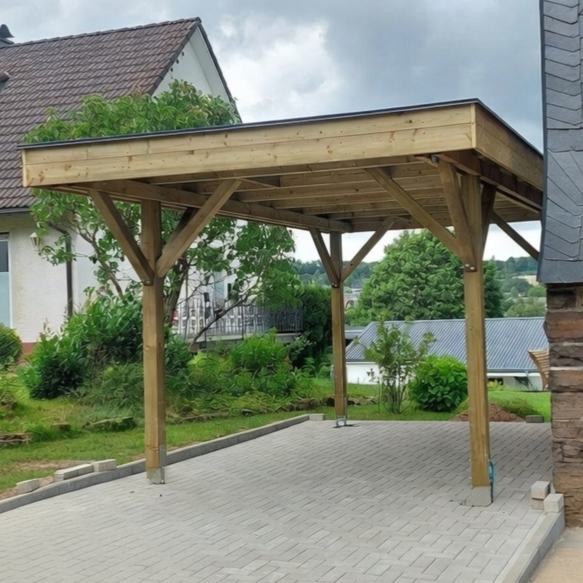 Holz Carport Arnsberg auf gepflasterter Einfahrt im Garten neben dem Haus
