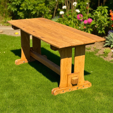 Eichen Gartentisch Valmetal auf dem Rasen vor einem blühenden Beet